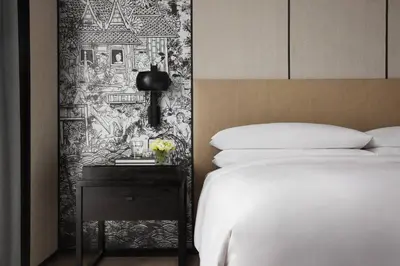 a bedroom with a bed and a side table with a bed sidx sidx at Bangkok Marriott Hotel The Surawongse in Bangkok