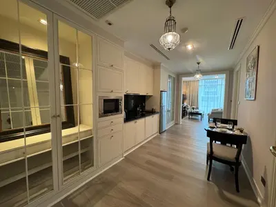 a kitchen with white cabinets and a table in a room at Rongratana Executive Residence Bangkok in Bangkok