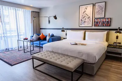 a hotel room with a large bed and a couch at Oakwood Residence Sukhumvit Thonglor Bangkok in Bangkok