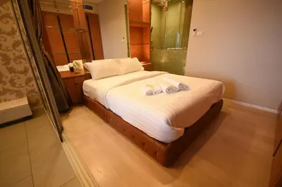 a bedroom with a bed with two towels on it at BoonRumpa Accommodation in Bangkok