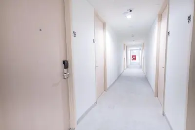 an empty corridor in an office building with white walls at BoonRumpa Accommodation in Bangkok