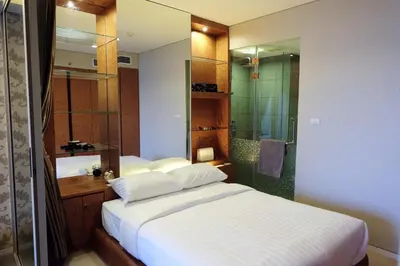 a bedroom with a large bed and a shower at BoonRumpa Accommodation in Bangkok