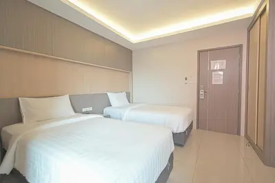two beds in a hotel room with white sheets at Sleep Hotel Bangkok in Bangkok