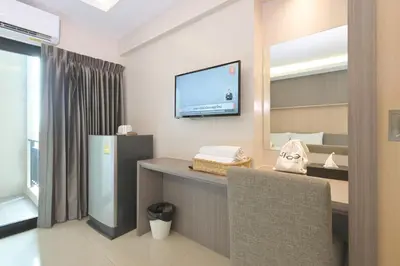 a living room with a television and a chair at Sleep Hotel Bangkok in Bangkok