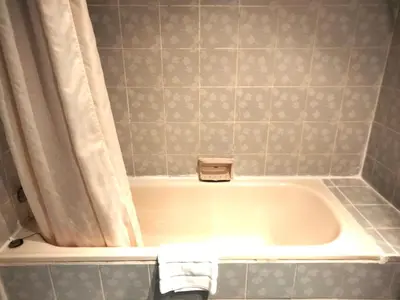 a bath tub in a bathroom with a shower curtain at City Lodge Bangkok in Bangkok