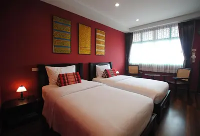 two beds in a room with red walls at Focal Local Bed & Breakfast in Bangkok