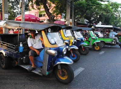 a row of motor scooters parked on a city street at Focal Local Bed & Breakfast in Bangkok