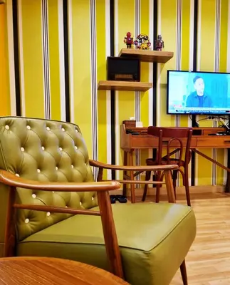 a living room with a chair and a television at Focal Local Bed & Breakfast in Bangkok