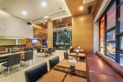 a restaurant with tables and chairs and a bar at M2 de Bangkok Hotel in Bangkok