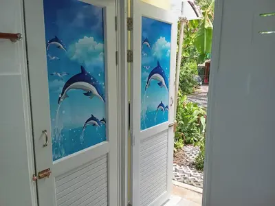 a door with dolphins in the water mural at Young and Beautiful in Bangkok