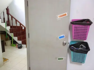 a door with a trash can and a basket on it at Young and Beautiful in Bangkok