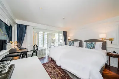 a hotel room with two beds and a television at Akara Hotel in Bangkok