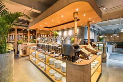 a restaurant with a counter with dishes on it at Akara Hotel in Bangkok