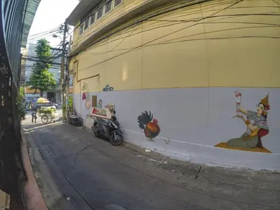 a building with a wall with paintings on it at KC guest house in Bangkok
