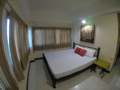 a bedroom with a white bed with two red pillows at KC guest house in Bangkok