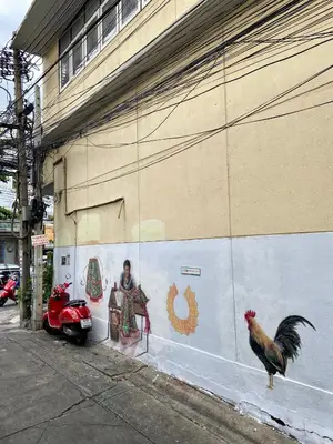 a mural of a man and chickens on the side of a building at KC guest house in Bangkok