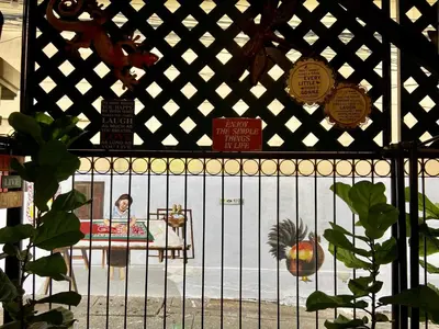 a woman sitting in a crib behind a fence at KC guest house in Bangkok
