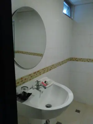 a bathroom with a sink and a mirror at Tongpoon Hotel in Bangkok