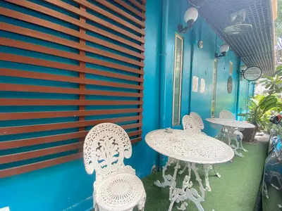 a patio with tables and chairs and a blue wall at Arawana Express Chinatown in Bangkok