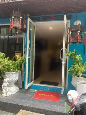 an open door of a building with two potted plants at Arawana Express Chinatown in Bangkok