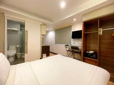 a bedroom with a white bed and a bathroom at Arawana Express Phromphong in Bangkok