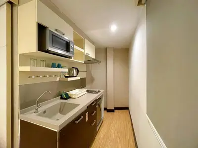 a small kitchen with a sink and a microwave at Arawana Express Phromphong in Bangkok