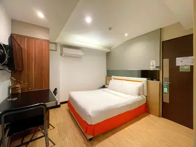 a hotel room with a bed and a desk at Arawana Express Phromphong in Bangkok
