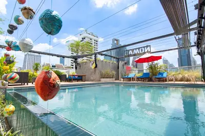 a swimming pool with beach balls and umbrellas on a building at Galleria 10 Hotel Bangkok in Bangkok