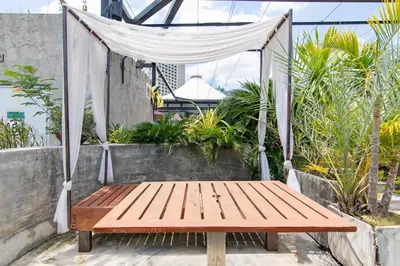 a wooden bench sitting on a patio with a canopy at Galleria 10 Hotel Bangkok in Bangkok