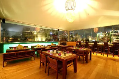 a restaurant with tables and chairs and a view of the city at Galleria 10 Hotel Bangkok in Bangkok
