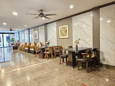 a restaurant with tables and chairs and a couch at Dynasty Inn in Bangkok