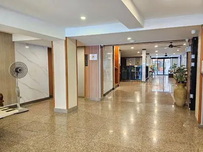 an empty lobby with a fan in a building at Dynasty Inn in Bangkok
