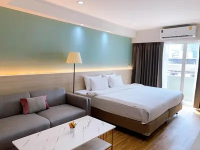 a hotel room with a bed and a couch at Miloft Sathorn Hotel in Bangkok