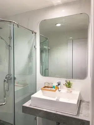 a bathroom with a sink and a shower and a mirror at Miloft Sathorn Hotel in Bangkok