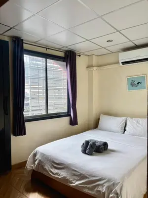 a bedroom with a bed with a stuffed animal on it at Double D Rooms & Cafe in Bangkok