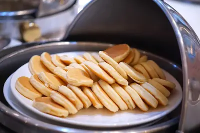a bunch of hot dogs on a plate in a toaster at Royal Benja Hotel - Big Rooms, Family Friendly in Bangkok
