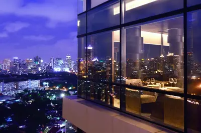 a view of a city at night from a building at AETAS lumpini in Bangkok