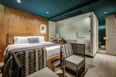 a hotel room with a bed and a chair at Sib Kao in Bangkok