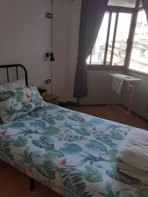 a bedroom with a bed with a colorful comforter at BaanSu Hostel in Bangkok