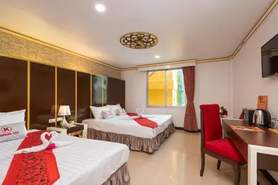 a hotel room with two beds and a desk and chair at Khurana Inn in Bangkok