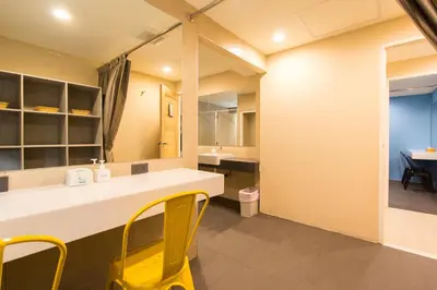 a bathroom with a yellow chair at a counter at Lazy Sunday hostel in Bangkok