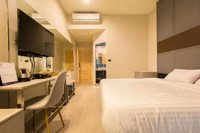 a bedroom with a bed and a desk with a computer at Lazy Sunday hostel in Bangkok