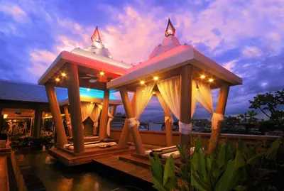 a resort with two gazebos in the water at night at Nouvo City Hotel in Bangkok