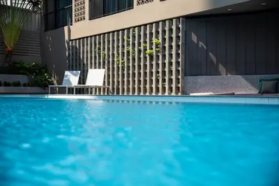 a swimming pool with blue water in front of a building at Reno hotel in Bangkok