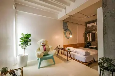 a teddy bear sitting on a chair in a bedroom at Pastelhouse hostel in Bangkok