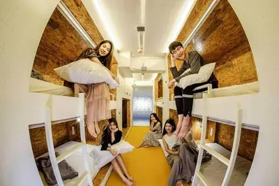 a group of people sitting in bunk beds at Pastelhouse hostel in Bangkok