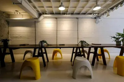 a large table and yellow chairs in a room at Pastelhouse hostel in Bangkok