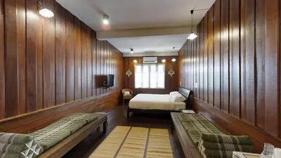 a room with two beds in a room with wooden walls at Home & Hashery Boutique House in Bangkok