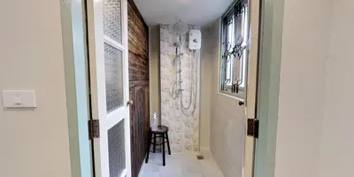 a hallway with a door leading to a bathroom at Home & Hashery Boutique House in Bangkok