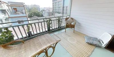a porch with a bench and a chair on a balcony at Home & Hashery Boutique House in Bangkok